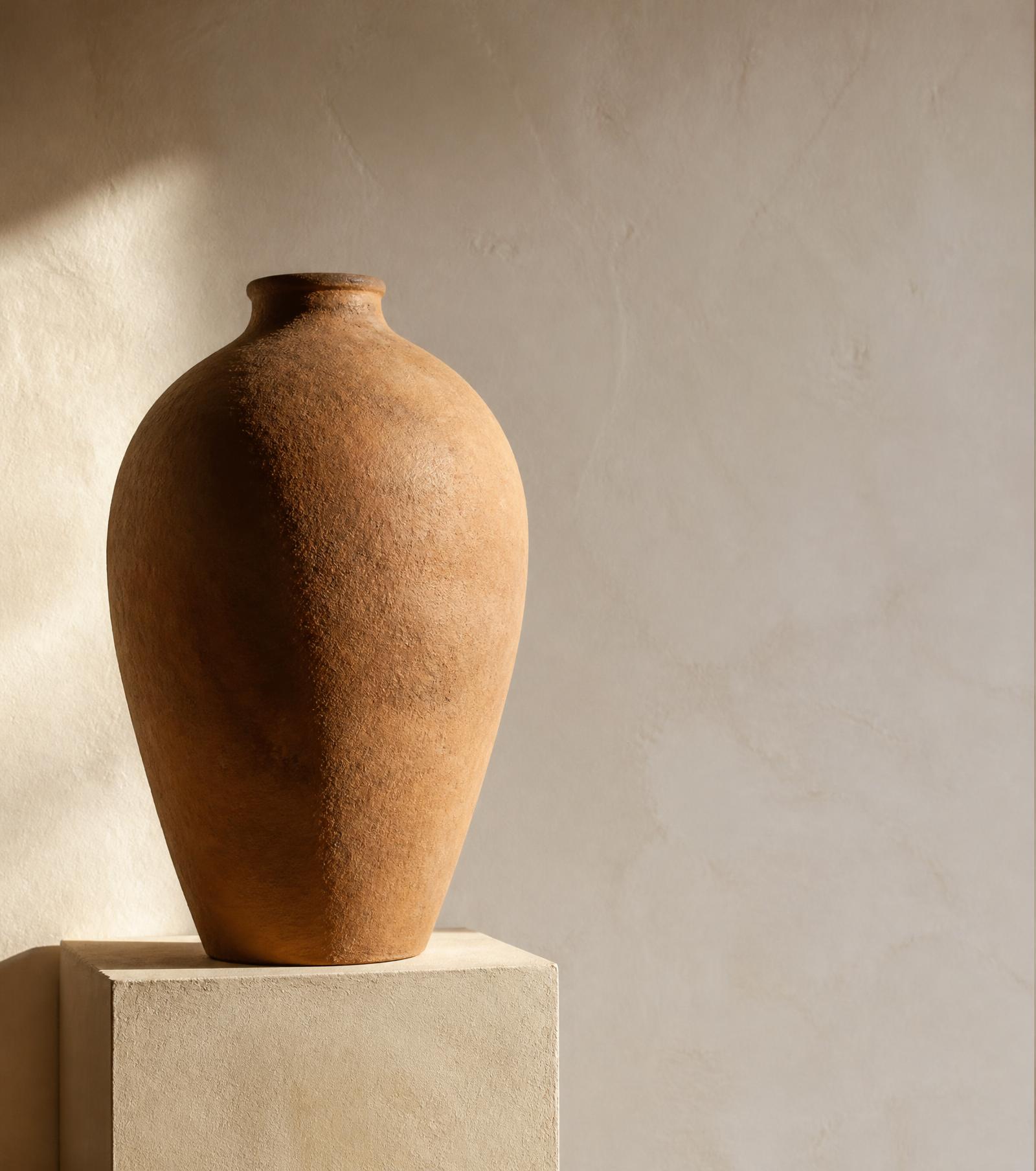 Handcrafted terracotta vessel on a plaster plinth